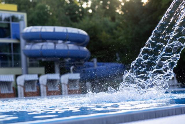 Freibad mit Rutsche im Hintergrund